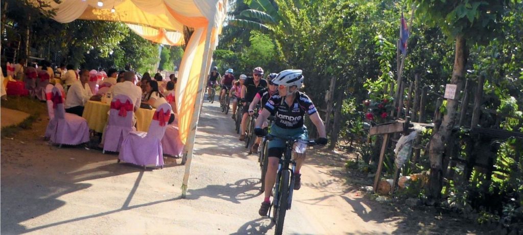 Cycling past a wedding in Cambodia Cycling past a wedding in Cambodia